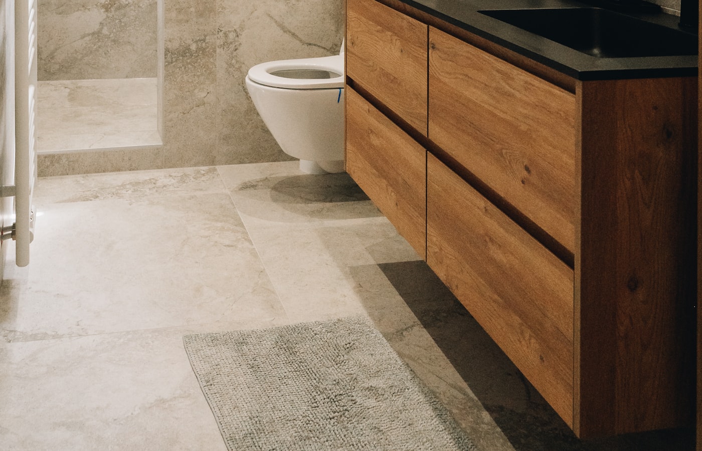 Salle de bain rénovée : douche à l'italienne, meuble-lavabo en bois et robinetterie noire